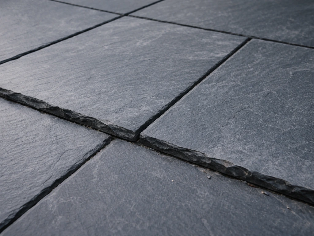 Close-up of a slate patio showing layered, cleft texture and flaking along slab edges